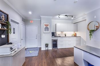 A kitchen with white cabinets and a wooden floor.